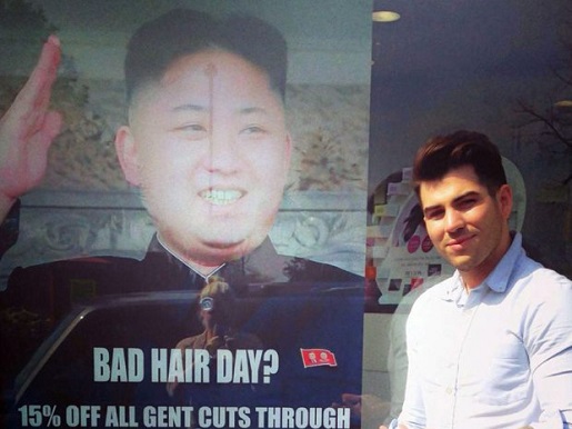 Barber Karim Nabbach poses in front of the poster that's angered North Korea.